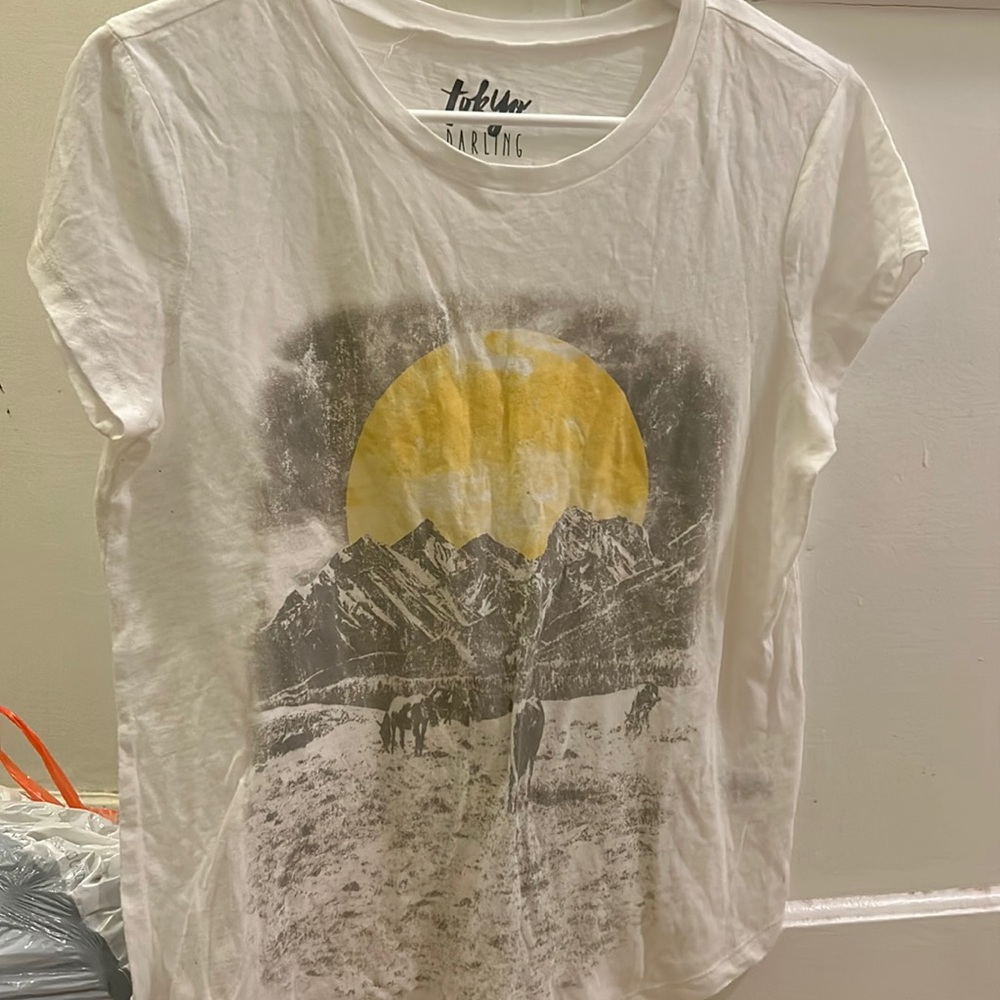 Has a very cute sunset on the shirt.